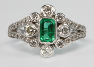 An 18ct white gold emerald and diamond open dress ring, size M