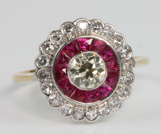 An 18ct yellow gold ruby and diamond target ring, size N 1/2