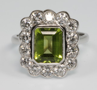 An 18ct white gold peridot and diamond cluster ring, the centre stone approx 1.35ct surrounded by 14 brilliant diamonds approx 2.3ct, size P