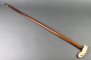 An Edwardian walking cane with a carved ivory twist handle