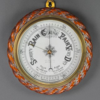 E E Williams of Newport, a late Victorian aneroid barometer with enamelled dial contained in a carved oak case with rope edge 11" 