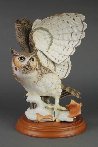 A Franklin Mint figure - The Great Horned Owl 14", on a wooden socle base 