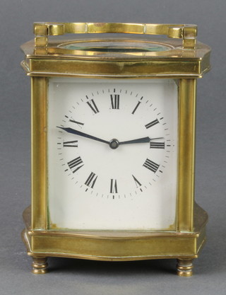 A 20th Century French 8 day carriage timepiece with enamelled dial and Roman numerals contained in a gilt metal case of serpentine form