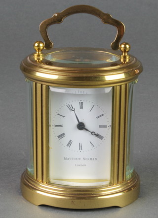 Matthew Norman, 20th Century oval Swiss carriage timepiece with enamelled dial and Roman numerals contained in an oval gilt metal case 3" 