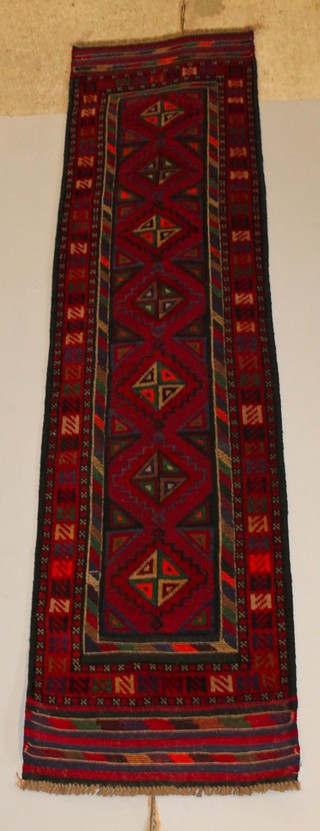 A red and blue ground Meshwani runner with stylised diamonds to the centre 106" x 26" 