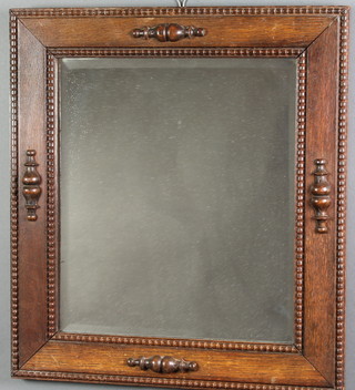 A bevelled plate wall mirror contained in a carved oak Jacobean style frame 21" x 19" 