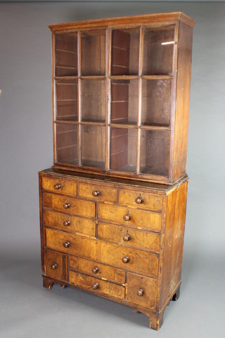 An 18th/19th Century walnut bookcase on cabinet, the associated top fitted adjustable shelves enclosed by astragal glazed panelled doors, the base fitted an arrangement of 3 short drawers above 4 long drawers above 1 long drawer and 2 short drawers flanked by 2 short drawers, raised on bracket feet 79"h x 39"w x 18"d