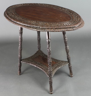 An oval carved Eastern hardwood 2 tier occasional table, raised on turned supports with shaped undertier 27"h x 31 1/2"w x 21"d 