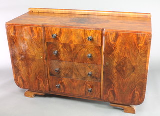 An Art Deco inverted breakfront sideboard with raised back, the quarter veneered top above 4 long drawers with tore handles, flanked by a pair of cupboards, raised on bracket feet 36"h x 54 1/2"w x 19"d 