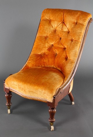 A Victorian mahogany show frame nursing chair upholstered in orange buttoned draylon, raised on turned supports 