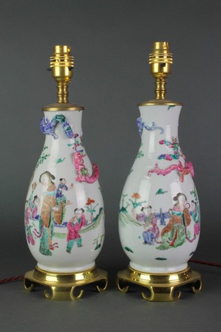 A pair of famille rose oviform vases decorated figures in garden landscapes applied with dragons, converted to electricity with gilt metal mounts 10" 