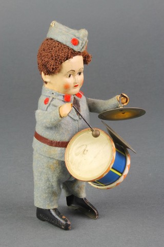 A Schuco tin plate and felt figure of a military drummer with side drum 5"