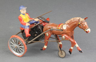 A clockwork tinplate and resin figure of a trotting cart with jockey 6" 