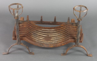 A 17th Century style iron fire grate with dogs 24"w x 13"d together with an arched fire back decorated a horseman 24"h x 20 1/2"w 