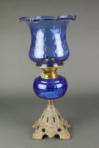 A Victorian blue glass oil lamp complete with shade raised on a pierced iron base 
