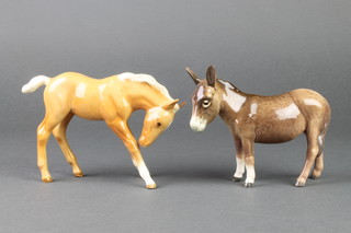 A Beswick figure of a standing donkey 5 3/4", a ditto of a foal 7"
