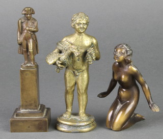 A bronze figure of a standing Napoleon raised on a square base 5", a bronze figure of a standing man with bird 5", a bronze figure of a nubian lady 4" 