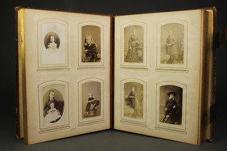A Victorian red leather photograph album containing a collection of various black and white portrait photographs