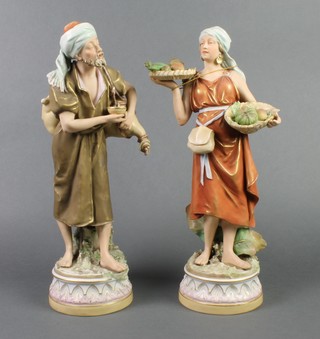 A pair of Royal Dux figures of male and female water carriers on raised bases 14 1/2" 