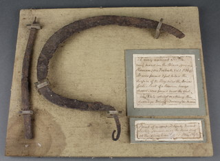 A "very ancient sickle" found 2 feet below the surface of a bog, together with part of a Roman bronze sword found in 1844, mounted on a display board 