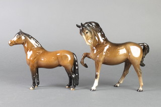 A Beswick figure of a standing horse with raised front right leg 9" and a figure of a standing race horse 8" 