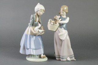 A Lladro figure of a girl with a basket of puppies 10", a ditto of a girl holding a goose 10" 