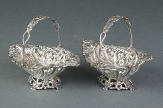 A pair of Victorian repousse silver bon bon baskets with swing handles, Birmingham 1894, 102 grams