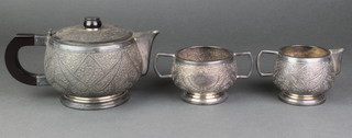An early 20th Century Indian repousse silver 3 piece tea set with ebony mounts, gross 802 grams