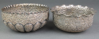 A pair of Indian repousse plated on copper bowls decorated with flowers 