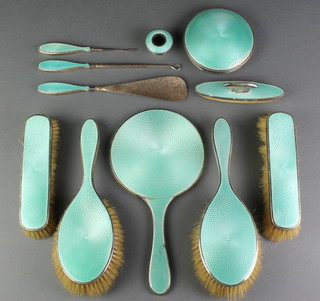 A silver and green guilloche dressing table set comprising 2 clothes brushes, 2 hair brushes, a hand mirror, shoe horn, nail buffer, manicure tool, button hook and 2 jar lids Birmingham 1927