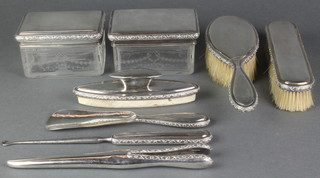A French silver Palaise Royale dressing table set comprising 2 rectangular cut glass boxes with silver lids, a silver backed clothes brush, hair brush, glove stretchers, button hook, shoe horn and nail buffer