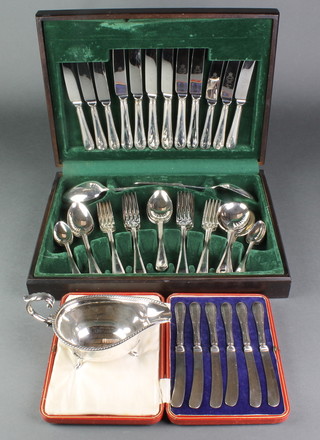 A silver plated sauce boat, 6 silver handled butter knives and a cased canteen