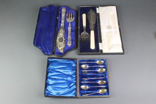 A pair of Edwardian silver  fish servers, cased and 1 other cased set and a cased set of 6 silver apostle spoons