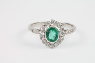 An 18ct white gold emerald and diamond cluster ring, size P