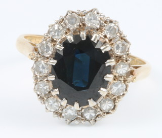 An 18ct yellow gold oval sapphire and diamond cluster ring, size N