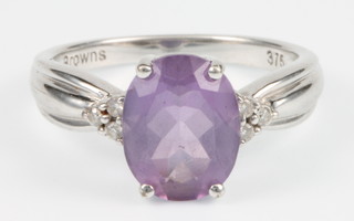 A 9ct white gold amethyst and diamond ring, the centre stone approx. 2cts flanked by 3 small diamonds to each shoulder, size M