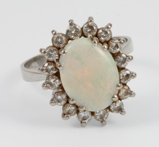 An 18ct white gold oval opal and diamond ring surrounded by 16 brilliant cut diamonds, size S 1/2