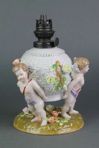 A 19th Century German porcelain lamp base in the form of 3 cherubs supporting a basket with clear glass funnel 7" 