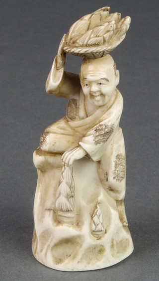 A Japanese ivory Okimono in the form of a man climbing a rock with a basket on his head 3 1/2" 