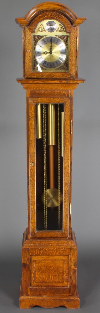 A chiming longcase clock with 7" arched gilt dial and silvered chapter ring contained in an oak case with sliding hood, raised on bracket feet 64 1/2"h 