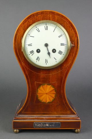 An 8 day striking mantel clock with enamelled dial and Roman numerals contained in an inlaid mahogany balloon shaped case, raised on bun feet 