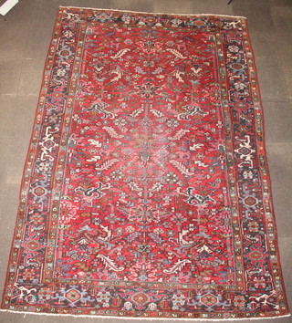 A Persian Heriz red and black ground carpet with floral decoration and black border 138" x 95" 