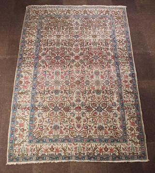 A cream ground and floral patterned Persian Tabriz carpet with blue borders 117" x 79" 