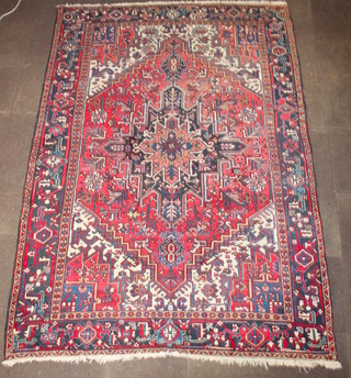 A Persian Heriz red and blue ground carpet with stylised star medallion to the centre 123" x 85" 