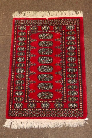 A red ground Bokhara slip rug with 8 octagons to the centre 