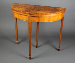 A Georgian style figured walnut demi-lune card table with crossbanded top, raised on square tapering supports, spade feet, 29 1/2"h x 33"w x 17"d 