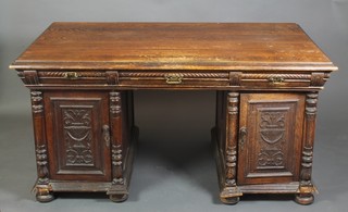 A Victorian carved oak partners desk, the upper section fitted 2 long drawers flanked by 4 short drawers, the pedestals fitted a pair of cupboards enclosed by panelled doors, raised on bun feet 33"h x 62 1/2"w x 39"d 