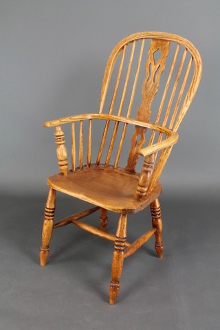 A 19th Century bleached elm comb back Windsor chair with H framed stretcher on turned supports 