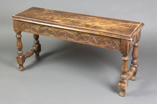 A rectangular carved oak free standing stool with arcaded decoration on turned and block supports 17"h x 36"w x 11"d 