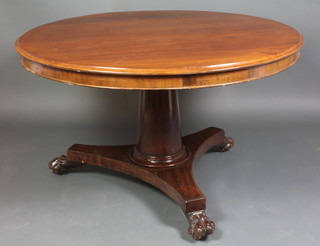 A circular Victorian mahogany snap top breakfast table, raised on a turned column and platform base, paw feet, 28"h x 47" diam. 